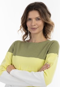 Maglione con strisce orizzontali verdi, gialle e bianche. Realizzato in morbido tessuto a maglia con collo rotondo e maniche lunghe, presenta una vestibilità comoda.