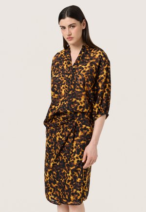 Leopardprint kjole med korte ærmer, med v-halsudskæring og samlet omslag i nuancer af gul, brun og sort.