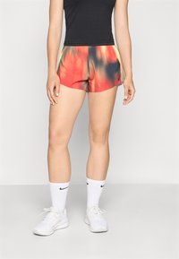 Fargerike, lette treningsshorts med et gradientmønster i rødt, oransje og gult. Har elastisk midje og sidelommer.