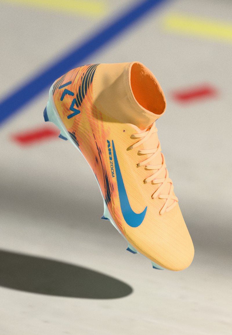 Botte de football jaune vif avec des accents bleus, surface texturée, design montante et logo de marque distinct. Dispose d'une semelle extérieure à multiples crampons.