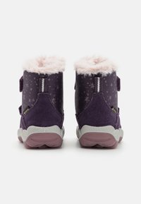 Bottes violettes imperméables avec doublure en fausse fourrure, dotées d'une sangle en velcro, en suède texturé, d'une tige synthétique à motifs et d'une semelle en caoutchouc.