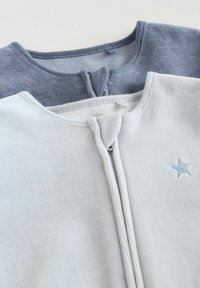 To sæt crew-neck sweatshirts stablet: en lys grå med en frontlynlås og blå stjernebroderi, den anden mørk grå, begge i blødt stof.
