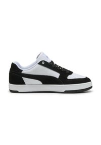 Zapatillas en blanco y negro con una mezcla de materiales de cuero y ante. Presentan una puntera perforada, diseño clásico con cordones y una suela de goma resistente.