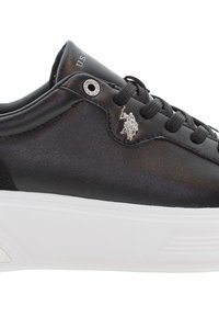 Zapatilla de cuero negro con acabado texturizado, suela de goma blanca, ojales plateados y un pequeño logo plateado en el lateral.