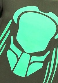 Zwart T-shirt met een groot, contrasterend neon groen grafisch ontwerp dat lijkt op een abstracte omtrek met gebogen en hoekige vormen.