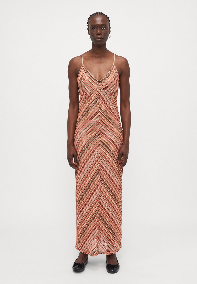 Maxi dress with thin straps, featuring a chevron pattern in warm tones of orange, red, and brown; made from a soft, textured fabric.