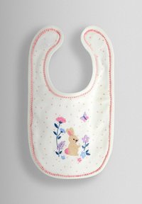 Biela bavlnená podbradník s ružovými bodkami, ružovým lemom a vyšívaným zajacom a kvetmi. Vyznačuje sa mäkkou textúrou a tvarom v tvare písmena U pre ľahké nasadzovanie.