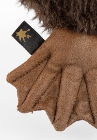 Brown textured fabric with a layered design resembling a leaf, featuring a black tag with a gold paint splatter pattern.