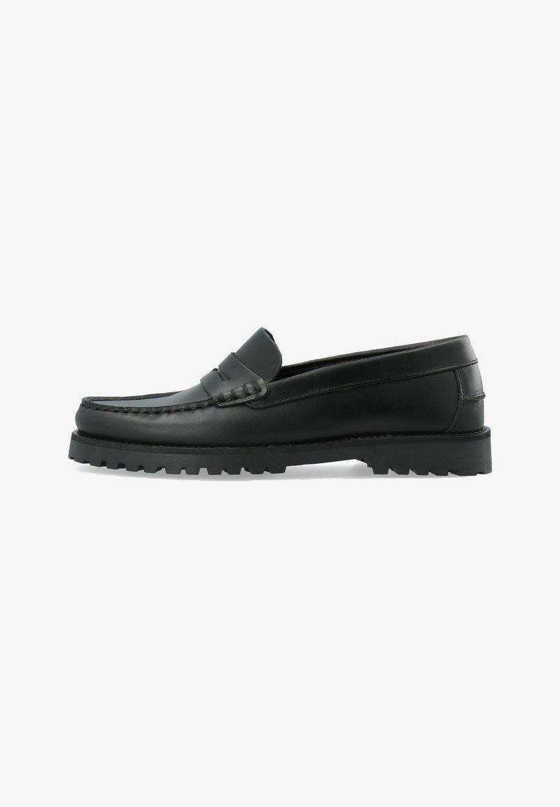 Mocassin en cuir noir avec semelle épaisse à crampons, coutures moc-toe et une bride sur le dessus, présenté en vue latérale sur fond blanc.