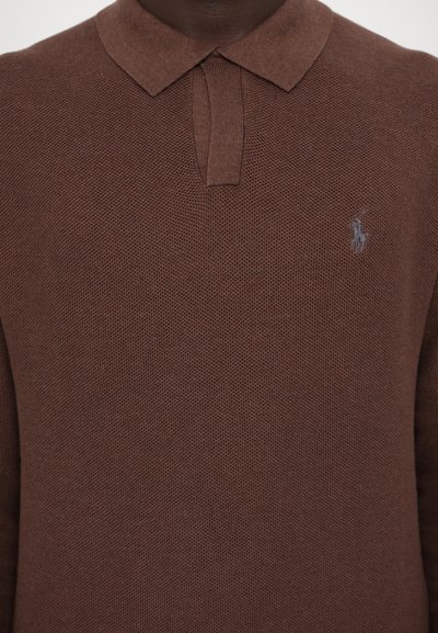 Brun polo-shirt lavet af strikket stof med et struktureret mønster. Har en klassisk krave og et lille logo på venstre side.