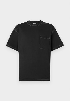 T-shirt noir à manches courtes en coton avec une poche sur la poitrine gauche, des coutures blanches contrastées et un col rond.