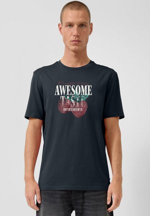 Man wearing black T-shirt with raspberry graphic and text "AWESOME" and "DON'T MESS WITH MY QS" on a plain background.