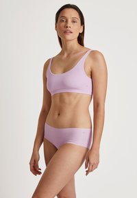 Svijetlopurple bralette i odgovarajući boxer gaćice, izrađeni od glatkog materijala. Jednostavan dizajn s širokim naramenicama i minimalnim brendingom.