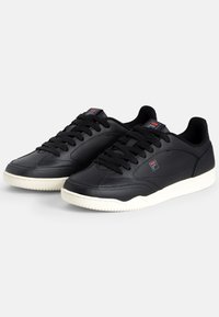 Svarta lädersneakers med en strukturerad yta, som har svarta snörningar, en vit gummisula och en liten logotypdetalj på tungan.