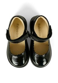 Un paio di scarpe Mary Jane nere lucide per bambini piccoli, con bordi a onde e cinturini regolabili su sfondo bianco.