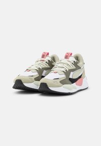 Tenisky s kombinací světle zelených, černých a bílých materiálů, s texturovanou podrážkou, výraznými tkaničkami a růžovými akcenty.