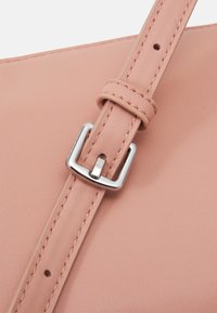 Cinghia per borsa in pelle rosa con fibbia in metallo argento, con cuciture visibili e superficie liscia.