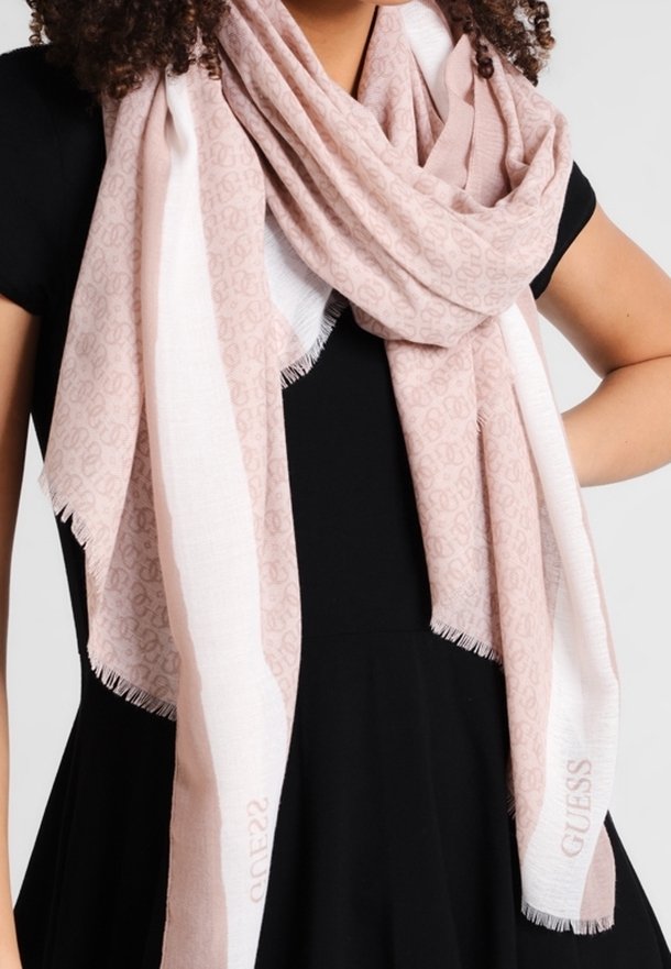 Femme portant une robe noire avec une grande écharpe douce rose et blanche drapée autour du cou et des épaules.