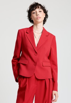 Red tailored blazer featuring notched lapels, two front pockets, and two buttons, made from a smooth fabric with a structured fit.