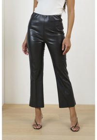 Svarta fusk-läderbyxor med slim fit, med hög elastisk midja och design av avskuren utsvängd ben. Slät textur, blank yta.