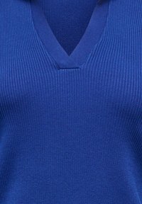 Maglione blu a costine in maglia con scollo a V e tessuto strutturato, che mette in risalto una finitura liscia e un colore uniforme in tutta la superficie.