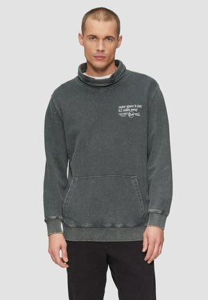 Grijze oversized sweatshirt met een funnelnek, een voork pocket en tekstprint. De witte tekst contrasteert met de stof, die een versleten textuur heeft.