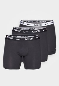 Tres pares de bóxers para hombre en gris oscuro, con cinturilla elástica y el logo de Nike en blanco, diseño ajustado.