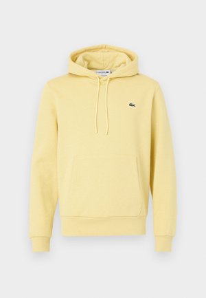 Yellow cotton hoodie with a kangaroo pocket, adjustable drawstring hood, and a green Lacoste logo on the left chest.