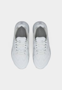 Ζευγάρι λευκά αθλητικά παπούτσια Reebok με κορδόνια, ορατά από ψηλά σε σκέτο λευκό φόντο.