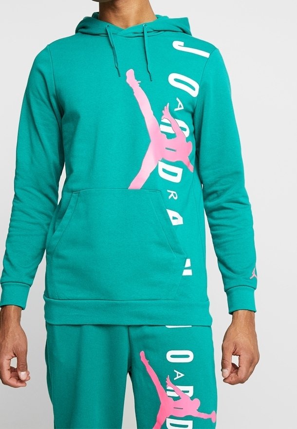 Hoodie teal avec une poche kangourou, comportant un grand logo Jumpman rose et le texte "JORDAN" en blanc sur le côté. Matière en coton.