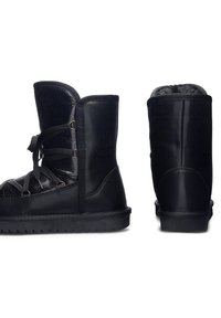 Mustad mustad jalatsid tekstuurse viimistlusega, sidumisega disain, siledad nahast küljed ja kummist põhi, millel on sakiline muster.