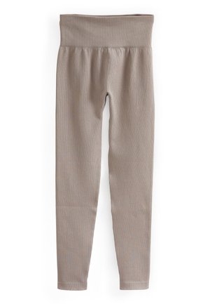 Beige geribbelde legging met een brede tailleband, taps toelopende benen en een gladde textuur, ontworpen voor comfort en flexibiliteit.