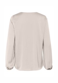 Top beige chiaro a maniche lunghe con una vestibilità comoda, scollo rotondo e polsini arricciati, realizzato in tessuto morbido e liscio.