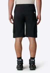 Black cargo shorts made of lightweight fabric, featuring two side pockets, a rear pocket, and a logo on the waistband.