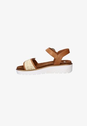 Brown and beige open-toe sandal with adjustable ankle strap and thick white sole on a white background.