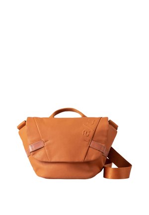 Borsa in pelle arancione con design triangolare, dotata di manico superiore, tracolla regolabile e logo in rilievo discreto. Texture liscia con dettagli minimali.