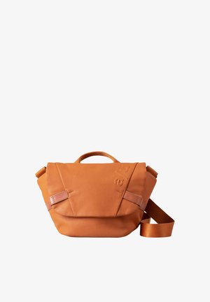Orange leather bag with a triangular design, featuring a top handle, adjustable strap, and subtle embossed logo. Smooth texture with minimal detailing.