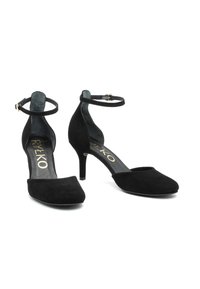 Zwarte suède dames schoenen met middelhoge hakken, enkelschoenen met banden en afgeronde vierkante neuzen, weergegeven van de voorkant en zijkant op een witte achtergrond.