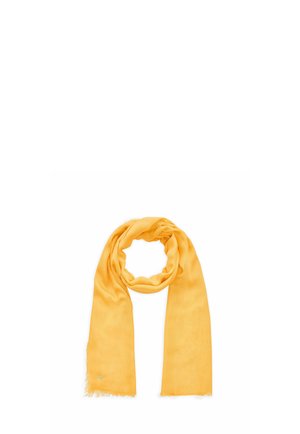 Gelber leichter Schal mit Fransen an den Rändern, locker zu einem Kreis gelegt auf weißem Hintergrund.