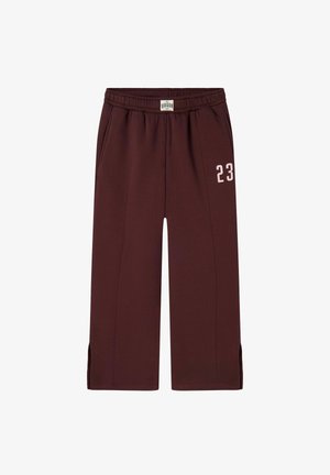 Burgundijske trenirke s pojasom na vezanje, bočnim džepovima i bijelom otisnutom brojkom "23" na lijevoj nozi. Imaju bočne proreze na rubu.