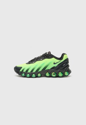 Nike shoes featuring a sleek design with a black and vibrant green color scheme, textured upper, and unique cushioned sole with green accents.