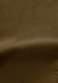 Texture di tessuto marrone con una superficie liscia e leggermente lucida, che presenta un colore uniforme e una sottile lucentezza su tutto il materiale.