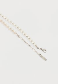 Κολιέ με πέρλες από λευκές στρογγυλές χάντρες και ασημένιο κούμπωμα μεσαίας μορφής, με ρυθμιζόμενη αλυσίδα που καταλήγει σε μικρή ορθογώνια πλακέτα.