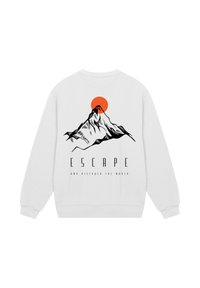 White sweatshirt with black mountain graphic and red sun above, featuring text "ESCAPE" and "and discover the world" below the design.
