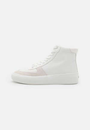 Hoge sneakers hebben een bovenwerk van witte textuurstof met lichtroze suède accenten en een witte rubberen zool, met veters geregen door metalen oogjes.