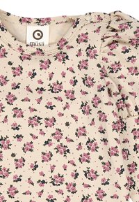 Vestito in cotone beige chiaro con motivo floreale rosa e blu navy, caratterizzato da dettagli arricciati sulle maniche e chiusura a scatto sulla spalla.