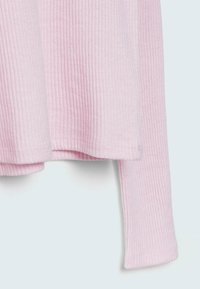 Růžový žebrovaný svetr s uvolněným střihem, dlouhými rukávy a bočními rozparky, vyrobený z měkké, elastické tkaniny.