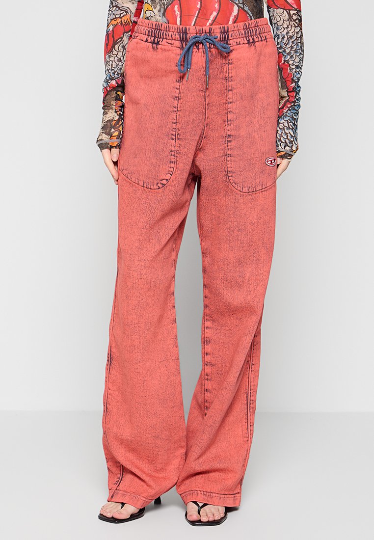 Pantalon en denim rouge avec une coupe décontractée. Doté d'une taille élastique avec un cordon bleu, de deux grandes poches avant et d'un détail de logo.