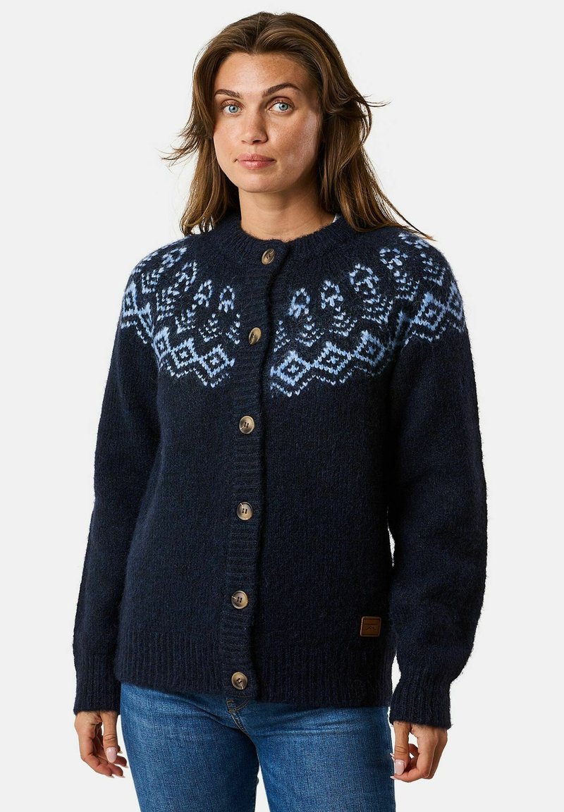 Marineblauwe gebreide cardigan met een ronde hals, voorzien van een gemusterde blauwe yoke en vijf bruine knopen aan de voorkant. Zachte textuur en geribbelde zoom.
