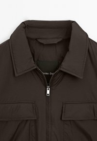 Dark brown padded jacket with a front zipper and two flap pockets below the chest, featuring a wide collar.